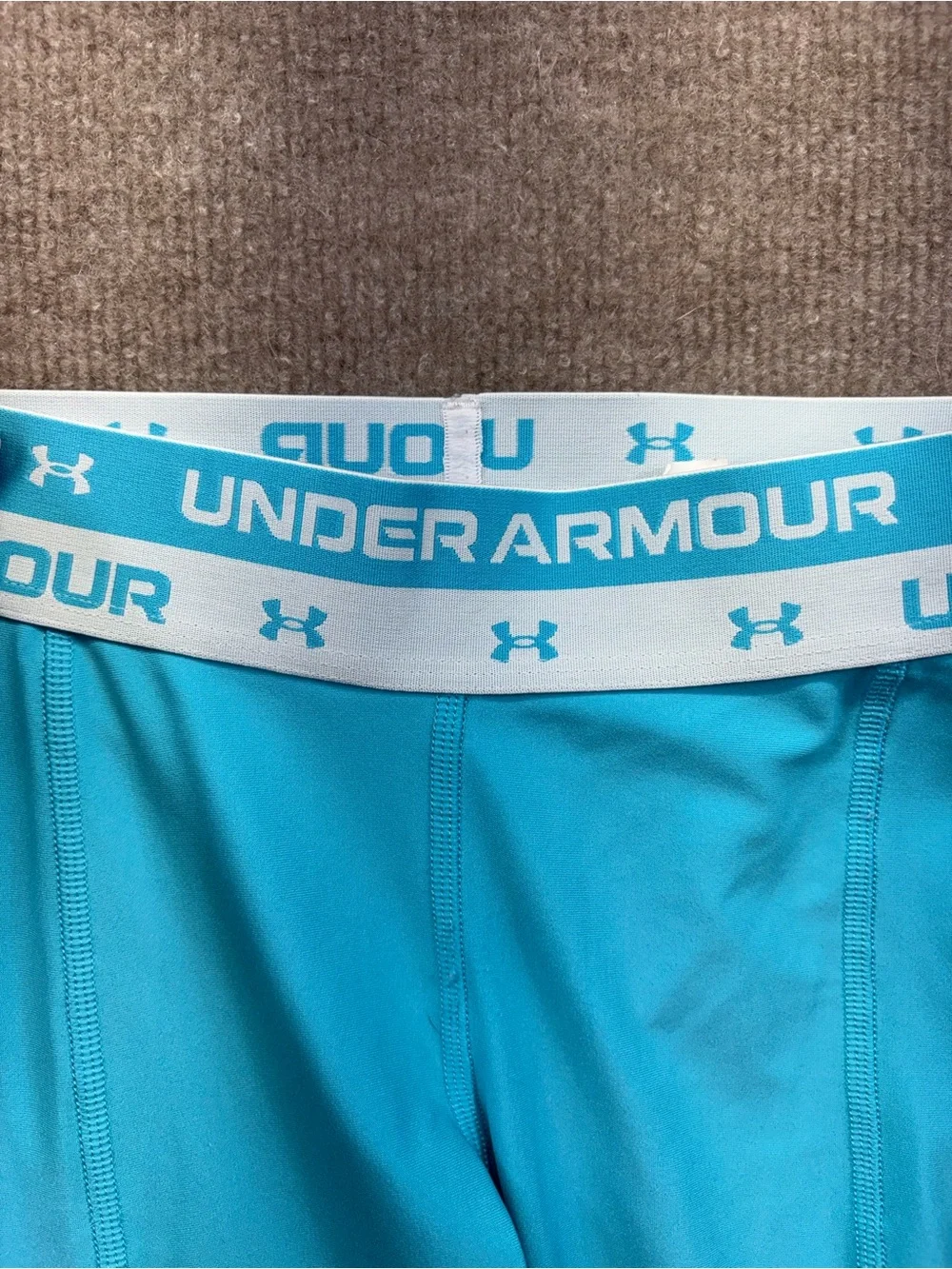 Under Armour YS are a teal blue with a logo elastic waistband